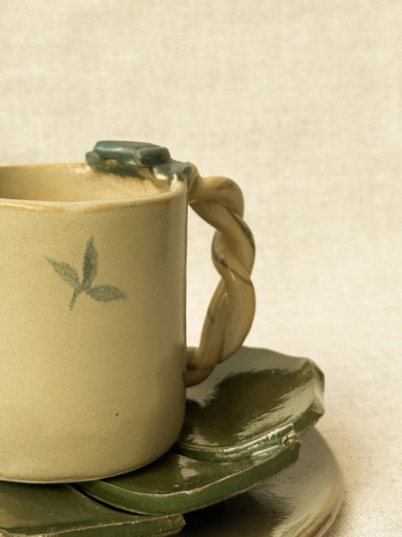 Caneca amarela apoiada sobre formas cerâmicas verdes