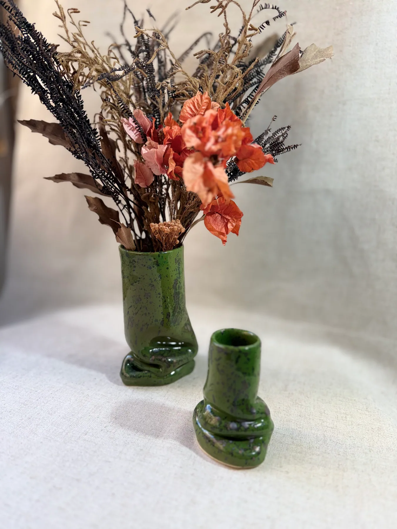 Vaso de cerâmica com flores e pequena peça sobre mesa
